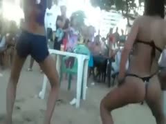 On the beach, an amateur brunette performs a twerking act.